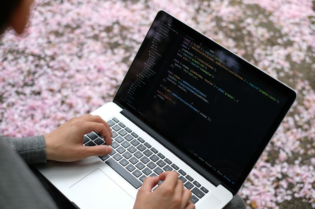developer writing code on laptop